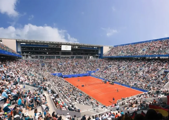 Match de tennis sur terre battue, stade plein.